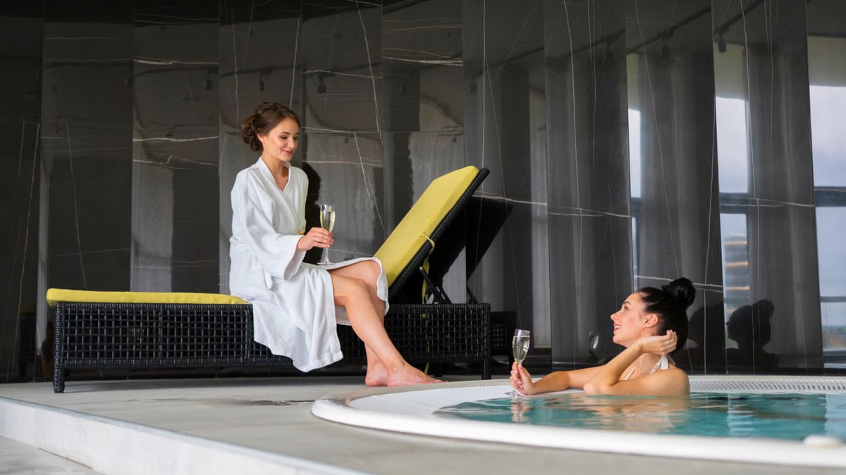 Two women enjoy a luxurious poolside moment with champagne, embodying relaxation and leisure.